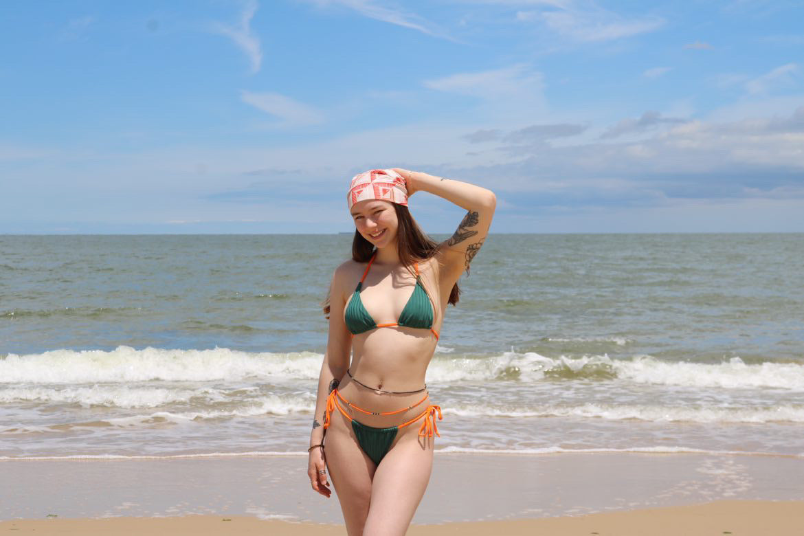 White woman on beach wearing Raine Waistbeads
